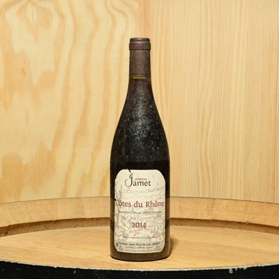 a bottle of wine sitting on top of a barrel