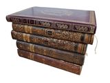 three old books stacked on top of each other on a white surface