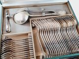 many spoons and silverware in a green box