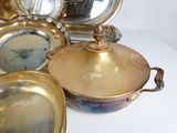 beaucoup de plats en laiton sur une table blanche