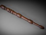an old wooden stick with a wooden handle sitting on a table