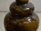 a brown vase sitting on top of a glass table
