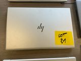 three laptops are sitting on a table with stickers on them