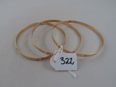 three gold bang bracelets with a price tag on a white background