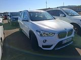 a white bmw suv parked in a lot with other cars