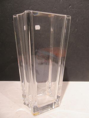 a clear glass vase sitting on a table with a black background