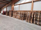 de nombreuses palettes de bois empilées dans un entrepôt