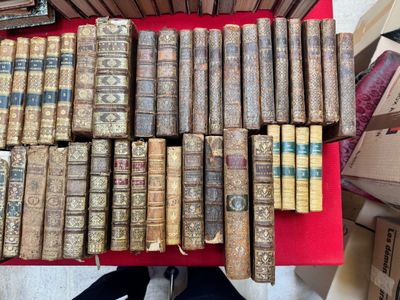 une image représentant une pile de vieux livres posée sur une table rouge