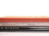 trois livres empilés sur une surface blanche