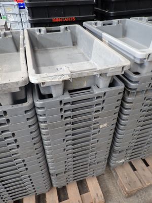 many plastic containers stacked on a pallet in a warehouse