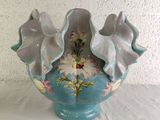 a blue vase with flowers on it sitting on a table