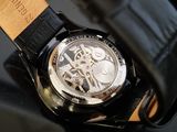 a close up of a watch on a black surface