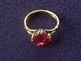 une bague en or avec une pierre rouge au centre