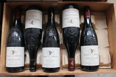 several bottles of wine are in a wooden box on a table