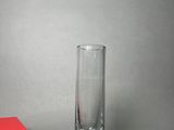 a red box next to a tall glass on a table