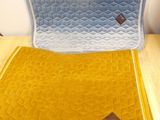 un coussin jaune et bleu posé sur le dossier d'une chaise