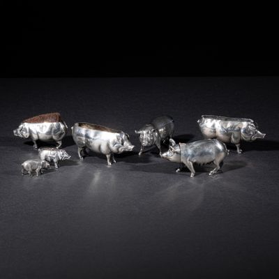 a group of silver figurines of animals on a black surface