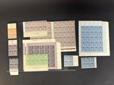 une table noire sur laquelle sont disposés de nombreux timbres différents