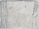 une image représentant une plaque en pierre sur laquelle est sculpté un bateau