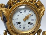 a gold and black clock with angels on it
