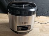 a silver and black crock pot on a wooden table
