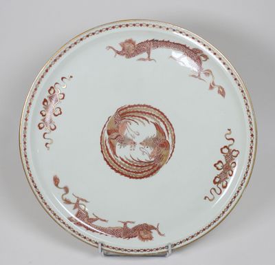 une image représentant une assiette ornée d'un dragon, posée sur un socle