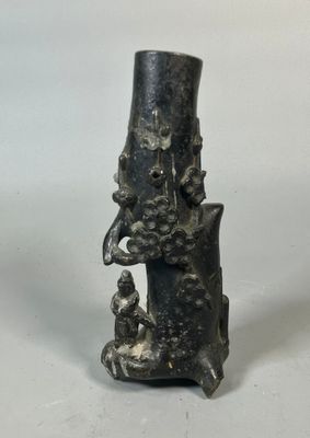 une image représentant un vase noir sur lequel est posée une statue