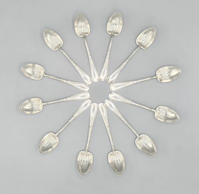 six cuillères en argent disposées en cercle sur une surface grise