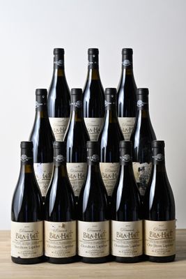 six bouteilles de vin sont alignées sur une table en bois