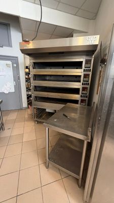 stainless steel ovens and tables in a commercial kitchen with tile flooring