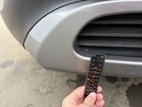a person holding a remote control in front of a car