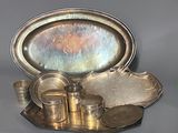 un plateau en argent sur lequel sont disposés des plats et des tasses en argent
