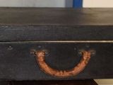 une valise noire posée sur une table en bois