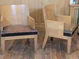 two wooden chairs sitting next to each other on a wooden floor