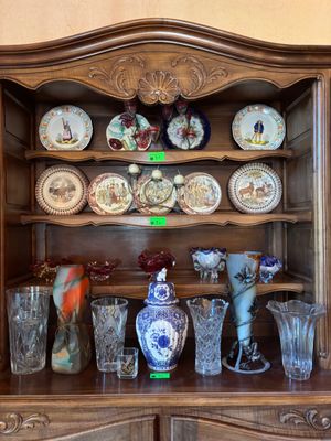 une vitrine en bois sur laquelle sont disposés de nombreux objets en verre