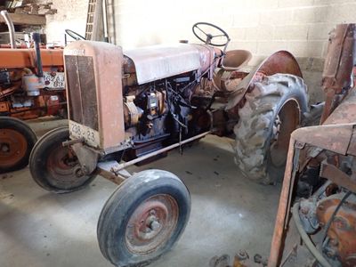 un tracteur qui est garé dans un garage avec d'autres tracteurs