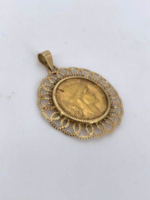 a gold coin pendant with an image of a woman on it