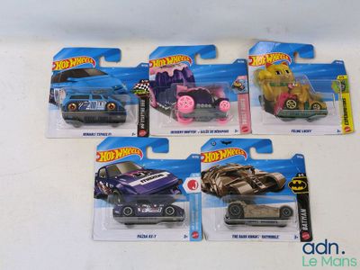 cinq petites voitures Hot Wheels dans le paquet posé sur la table