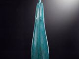 un vase en verre bleu posé sur une table noire
