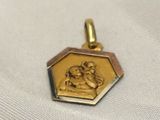 an image of a gold plated pendant with an image of a woman holding a child