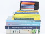 several books are stacked on top of each other on a white surface