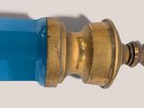 a close up of a blue glass and brass faucet
