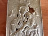 a close up of a plaque on a wooden table with a picture of a woman holding a child