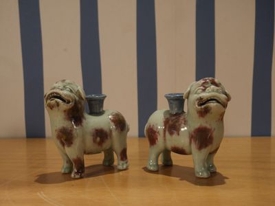 deux figurines de chiens posées sur une table à rayures bleues et blanches