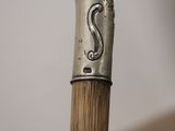 a close up of a wooden stick with a metal handle