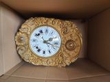 a clock inside of a box with a gold frame