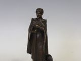 statue représentant un homme avec un chien et un chat, posée sur un socle blanc
