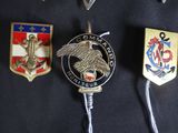 badges on a police officer ' s uniform are displayed on a black background
