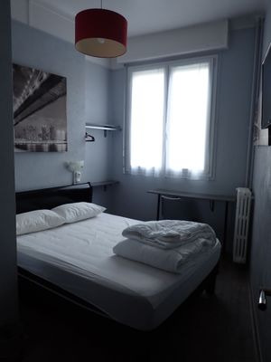a bed in a small room with a red lamp above it