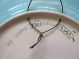 un gros plan d'une assiette bleue et blanche sur laquelle figure une horloge
